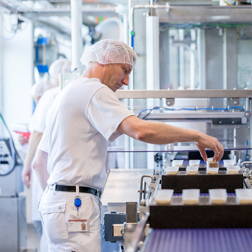 Fabrikmitarbeiter steht an einer Maschine